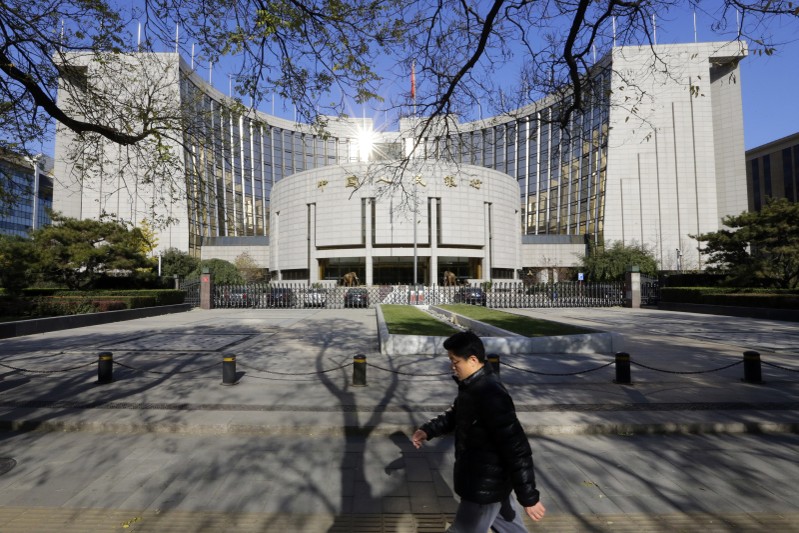 A man walks past the headquarters of the PBOC in Beijing