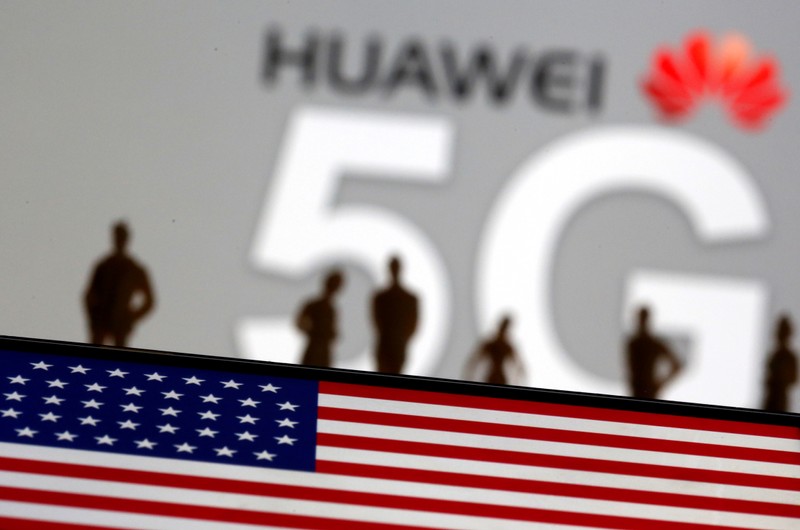FILE PHOTO: Small toy figures are seen in front of a displayed Huawei and 5G network logo in this illustration picture