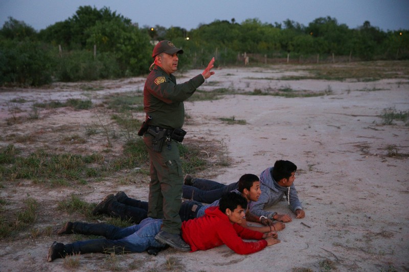 Border patrol agent Sergio Ramirez apprehends immigrants who illegally crossed the border from Mexico into the U.S., near McAllen