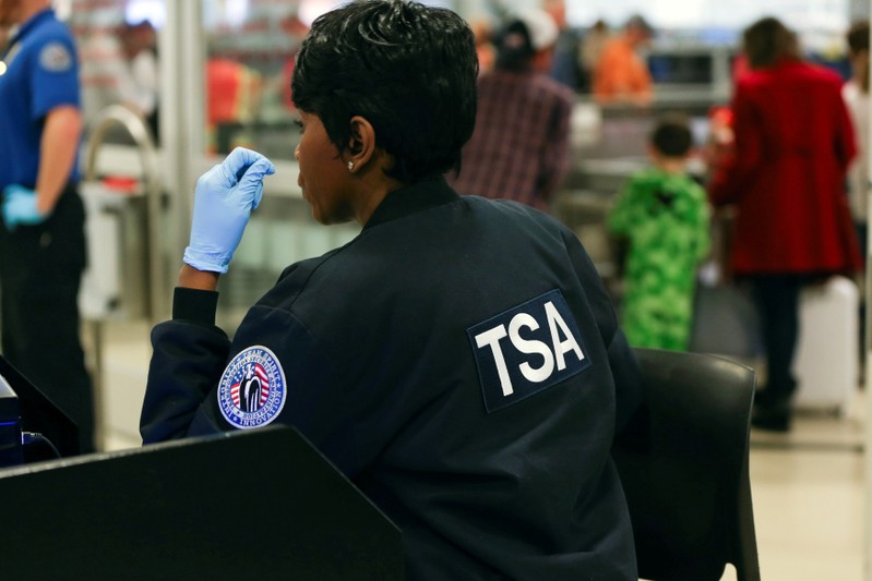 FILE PHOTO - A TSA agent screens passengers at a security checkpoint at Hartsfield-Jackson Atlanta International Airport amid the partial federal government shutdown, in Atlanta