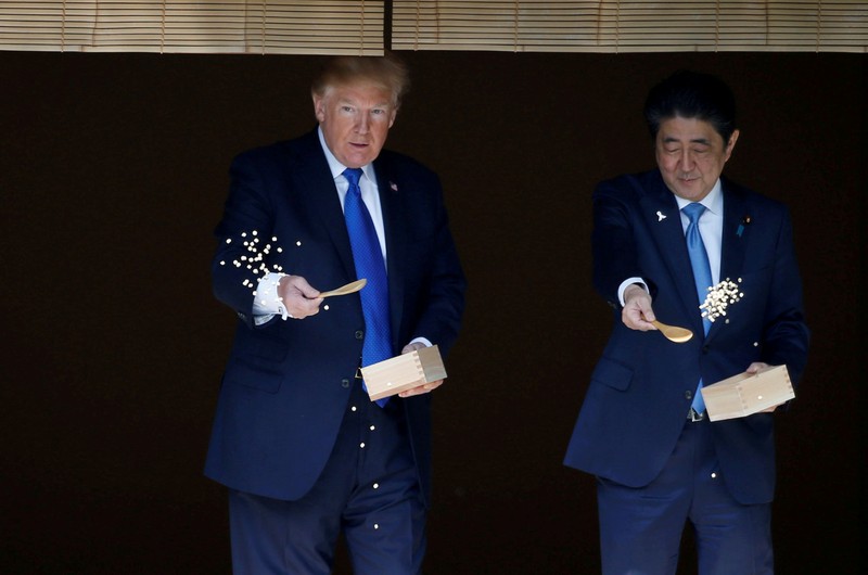 FILE PHOTO : U.S. President Donald Trump and Japan's Prime Minister Shinzo Abe feed carp before their working lunch at Akasaka Palace in Tokyo