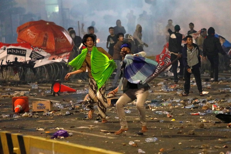 Protesters hurl stones during a riot near the Election Supervisory Agency (Bawaslu) headquarters in Jakarta