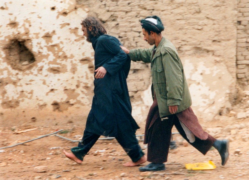 FILE PHOTO: U.S.-born John Walker Lindh is led away by a Northern Alliance soldier after he was captured near Mazar-i-Sharif