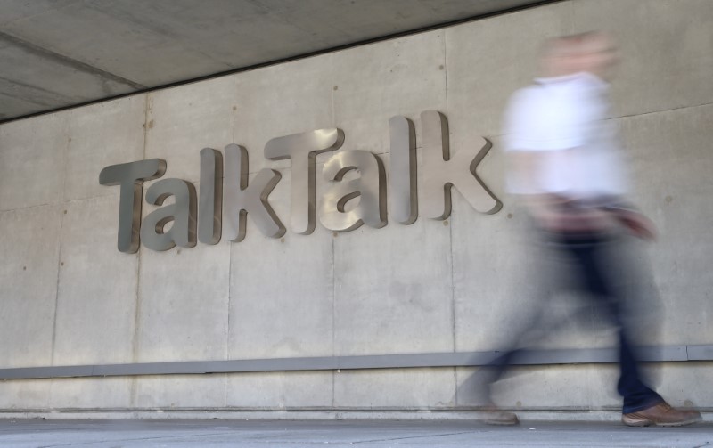 A man passes a branded logo outside the Talktalk headquarters in London