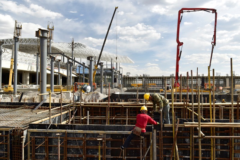 Men work on the construction site of the Zhangjiakou South railway station in Hebei