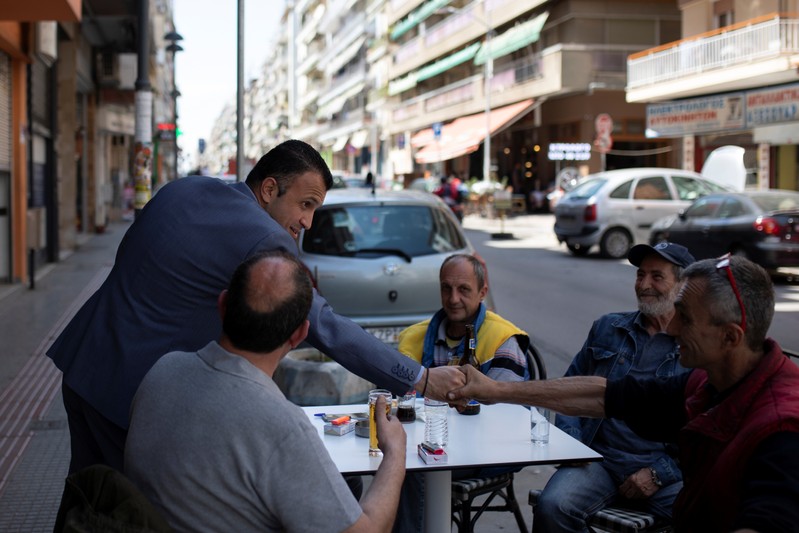 Undertaker and candidate for town councillor at the municipality of Sykies, Baboulas, greets locals next to his family's funeral parlor in Thessaloniki