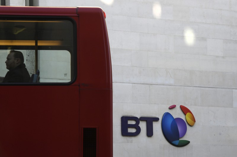 A bus passes a BT logo outside of offices in the City of London