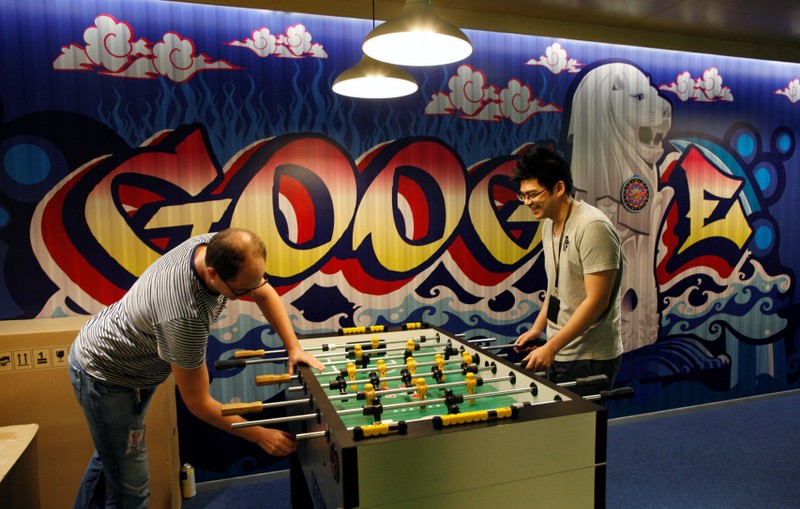 FILE PHOTO: Google's communications manager Moroney plays table soccer with a Google employee at a recreational area of their Singapore office