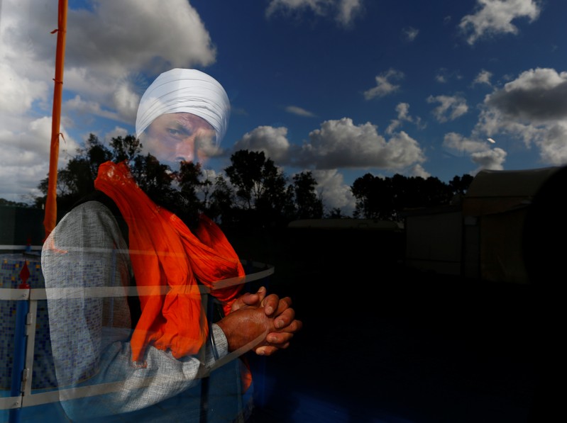 A Sikh migrant worker looks through a window of the temple in Borgo Hermada, in the Pontine Marshes, south of Rome