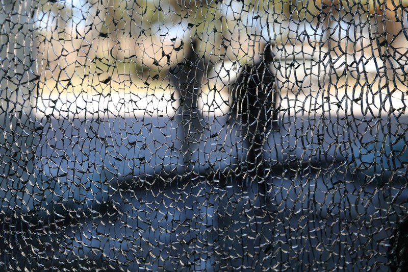 Men walk in front of Rixos hotel damaged by a rocket in Tripoli,