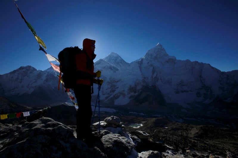 FILE PHOTO: A trekker stands in front of Mount Everest at Kala Patthar in Solukhumbu District