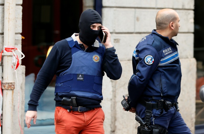 Police officers are seen near the site of a suspected bomb attack in central Lyon