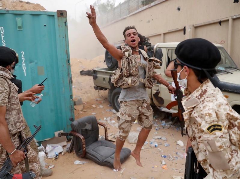 A fighter loyal to Libya's U.N.-backed government (GNA) gestures during clashes with forces loyal to Khalifa Haftar on the outskirts of Tripoli