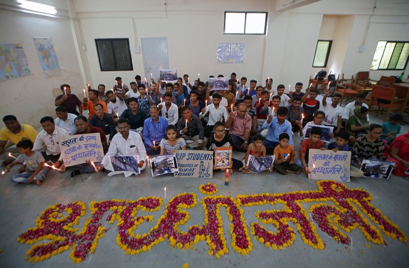People attend a prayer meet to pay tribute to the victims of a fire that broke out in a commercial building in the western city of Surat on Friday, inside a library in Ahmedabad