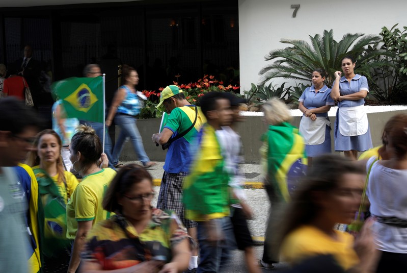 Hotel maids, observe demonstrators during a pro-government demonstration near Copacabana beach in Rio de Janeiro