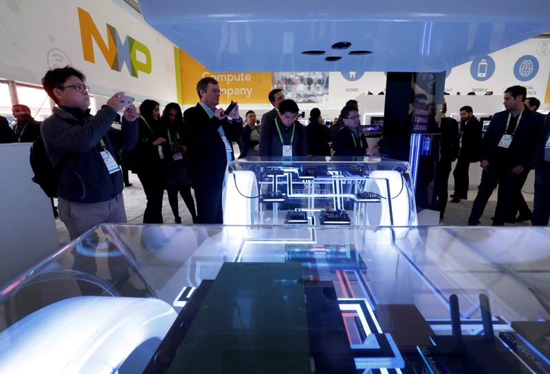People look over a display in the NXP booth during the 2019 CES in Las Vegas