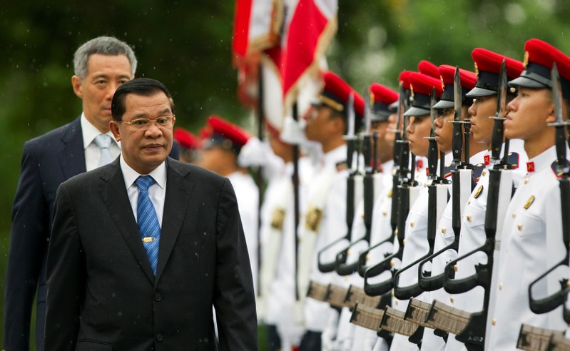 FILE PHOTO: Cambodia's PM Hun Sen inspects an honour guard as Singapore's PM Lee Hsien Loong walks behind him at the Istana in Singapore