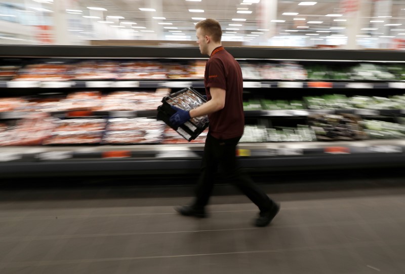 FILE PHOTO: A Sainsbury's worker stacks a vegetable shelf in a store in Redhill