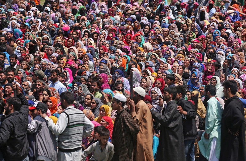 People watch the body of Imran Ahmad Bhat, a suspected militant, who was killed during a gun battle with Indian security forces today, during his funeral procession in Arihal village in South Kashmir's Pulwama