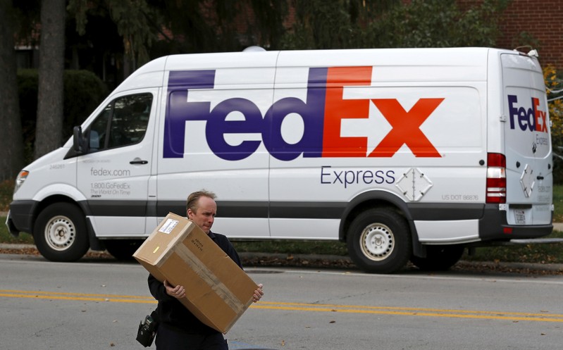 FILE PHOTO: A FedEx delivery worker carries a package for a delivery in Wilmette