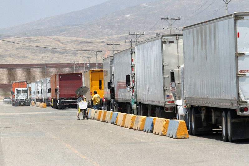 Trucks wait in queue for border customs control at the Otay border crossing in Tijuana