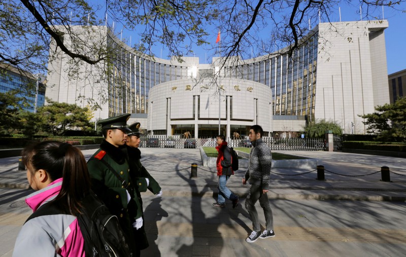 FILE PHOTO: People walk past PBOC headquarters in Beijing