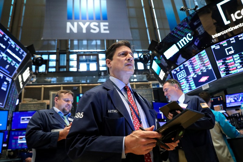 FILE PHOTO: Traders work on the floor at the NYSE in New York
