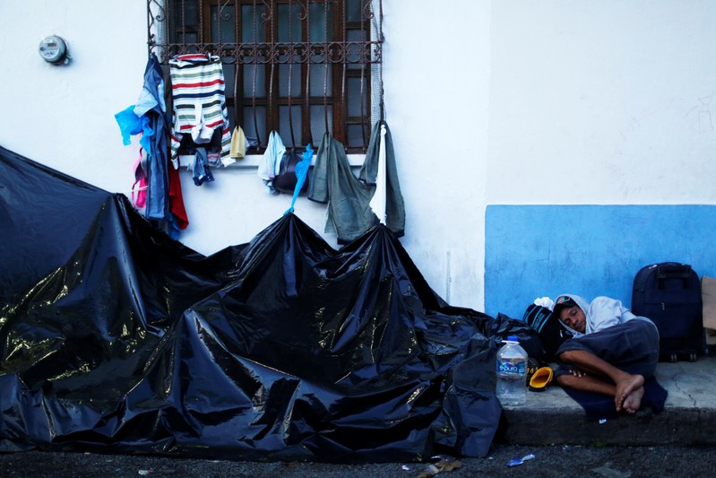Central American migrants wait outside the Mexican Commission for Refugee Assistance (COMAR) in Tapachula