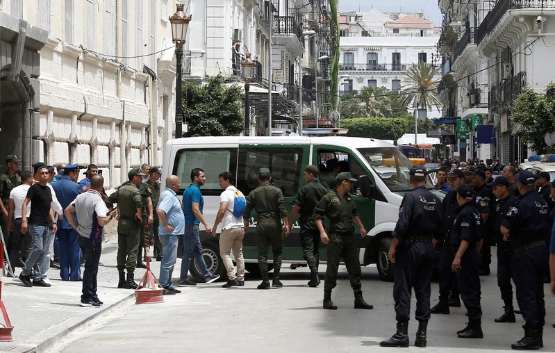Police officers and members of national gendarmerie stand guard outside a court in Algiers