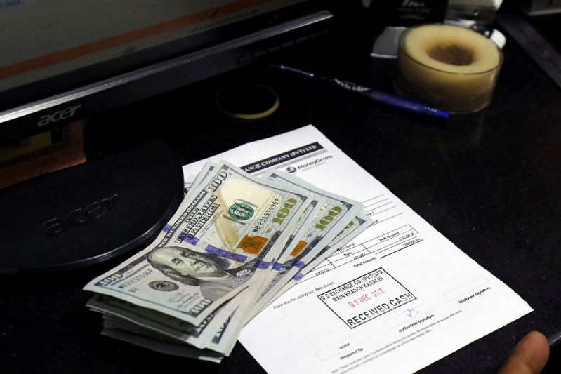 FILE PHOTO: U.S. dollar notes are seen on a desk at a currency exchange booth in Karachi