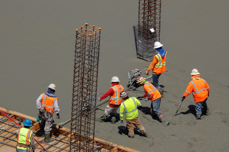 FILE PHOTO: Workers pour cement at a construction site for an office town in downtown San Diego