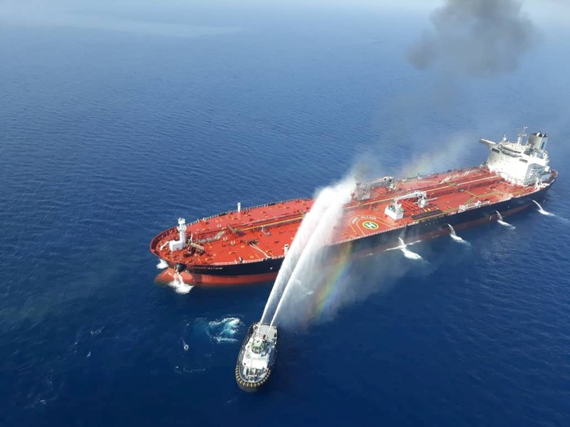 FILE PHOTO: An Iranian navy boat tries to stop the fire of an oil tanker after it was attacked in the Gulf of Oman