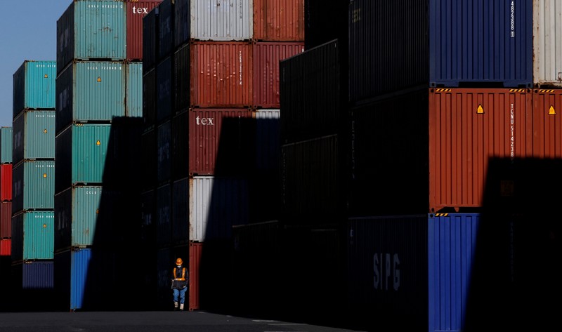 FILE PHOTO: Worker walks in a container area at a port in Tokyo