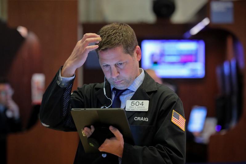 FILE PHOTO: Traders work on the floor at the NYSE in New York