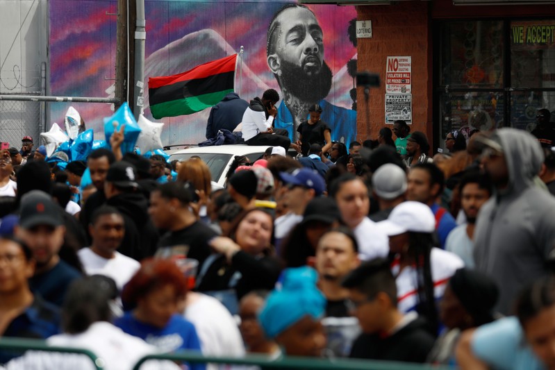 Fans wait for the funeral procession following a memorial for rapper Nipsey Hussle along Slauson Avenue in Los Angeles