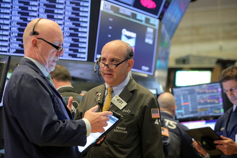 FILE PHOTO: Traders work on the floor at the NYSE in New York