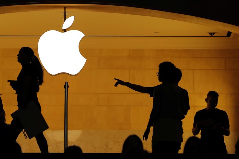 FILE PHOTO: Customers walk past an Apple logo inside of an Apple store at Grand Central Station in New York