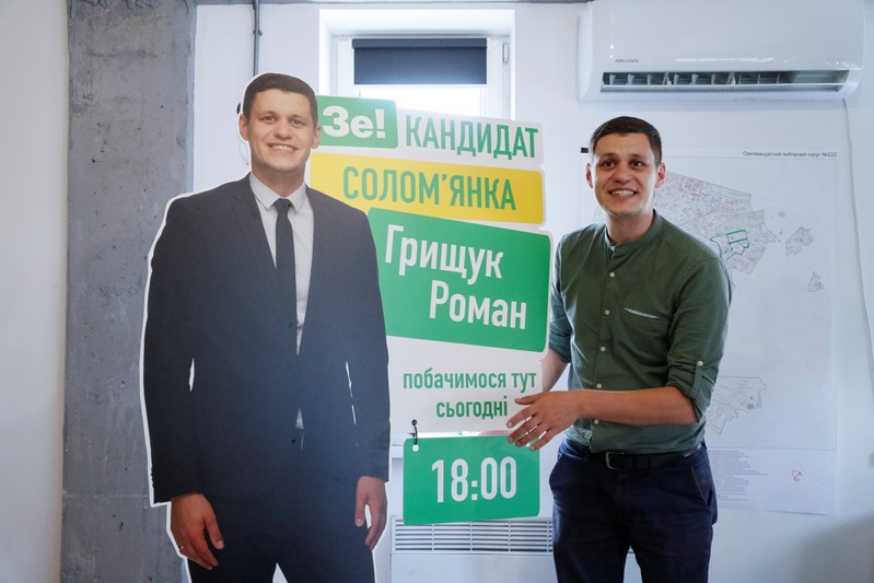 Roman Hryshchuk shows a banner with a life-size cutout of himself at his election headquarters in Kiev