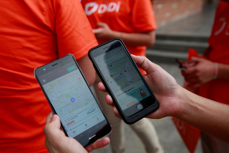 FILE PHOTO: An employee shows the app of China's Didi Chuxing as they launches their ride service in Toluca,