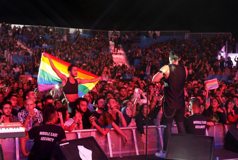 FILE PHOTO: A fan of Lebanese alternative rock band Mashrou' Leila holds a rainbow flag during their concert at the Ehdeniyat International Festival in Ehden town