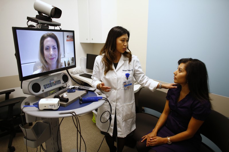 Nurse introduces patient to doctor who appears on a video screen remotely at a newly opened Kaiser Permanente health clinic inside a Target retail department store in San Diego