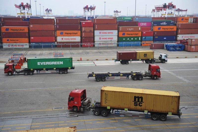 Trucks transport containers at a port in Qingdao, Shandong