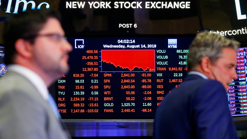 A screen shows the numbers after the closing bell as traders work on the NYSE floor in New York