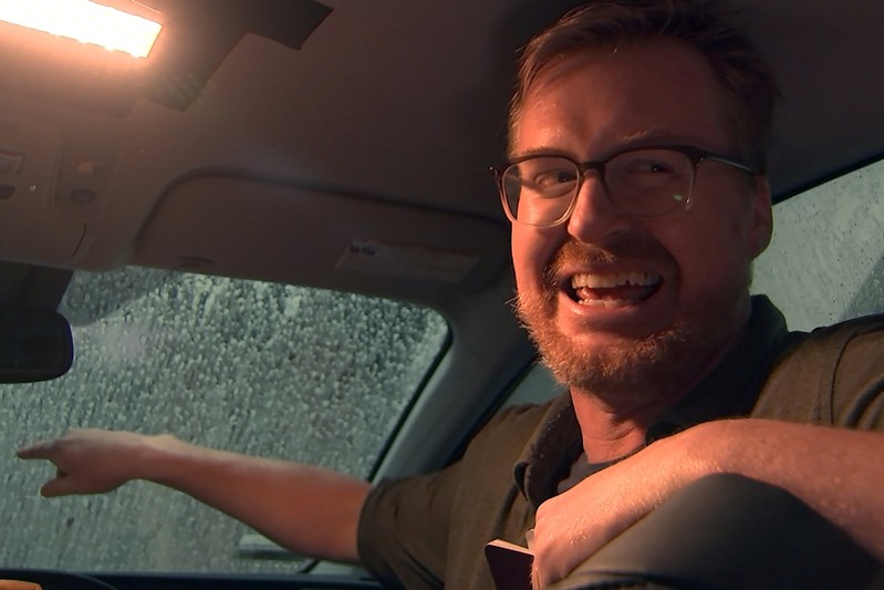 Comedian Kurt Braunohler laughs as he tells a joke in a car during a