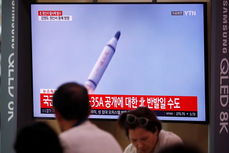 People watch a TV screening of a file footage in Seoul following North Korea's firing of missile believed to be launched from a submarine