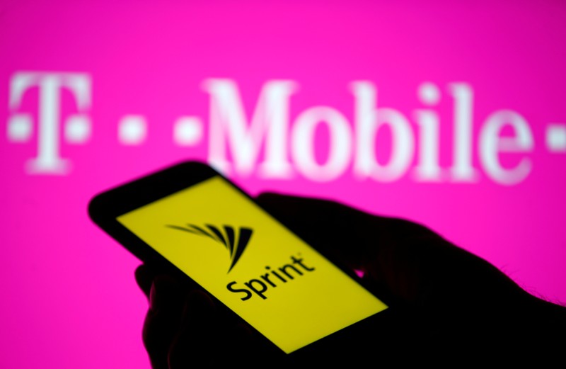 A smartphone with Sprint logo are seen in front of a screen projection of T-mobile logo, in this picture illustration