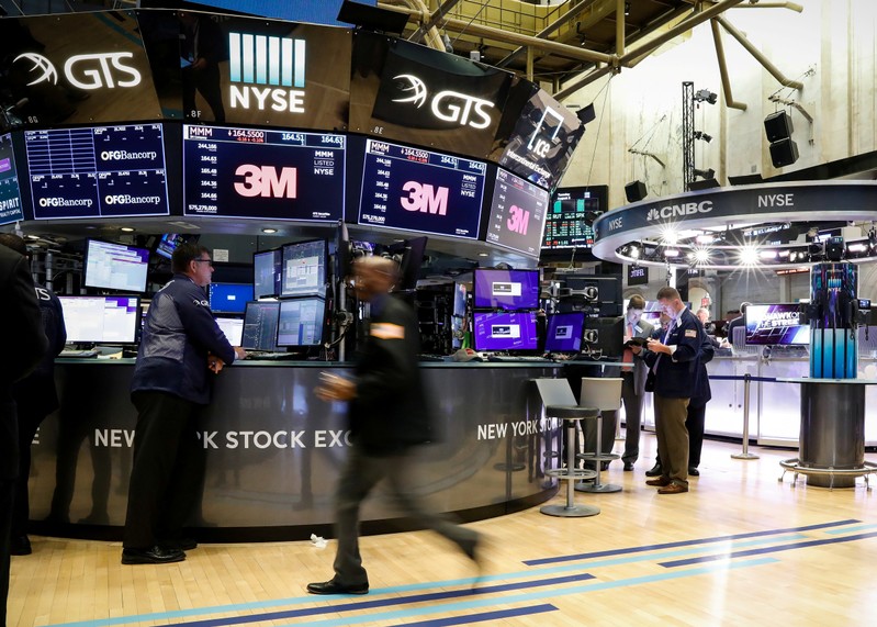 FILE PHOTO: Traders work on the floor at the NYSE in New York