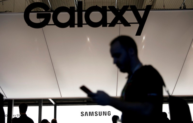FILE PHOTO: A visitor uses a mobile phone at the Samsung booth at the Mobile World Congress in Barcelona