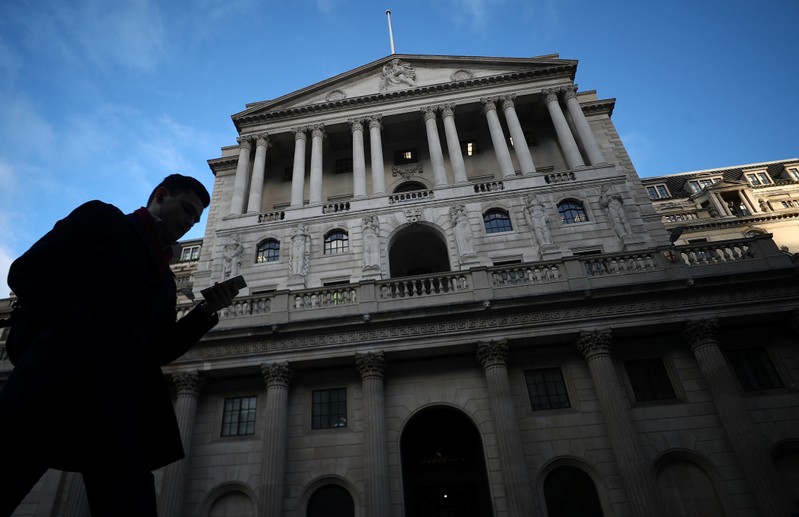 FILE PHOTO: A man walks past the Bank of England in the City of London