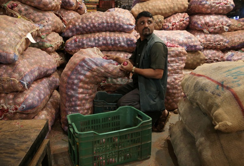 FILE PHOTO: A man sorts onions at a vegetable wholesale market in Mumbai